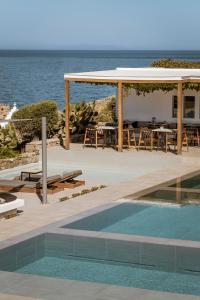 a resort with a swimming pool and a pavilion at Mykonos Soul Luxury Suites in Agios Stefanos
