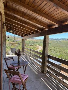 einen Tisch und Stühle auf einer Veranda mit Aussicht in der Unterkunft Casa da Tapada Santo Antonio in Branda de Santo António