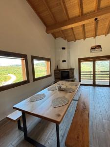 einen großen Holztisch in einem Zimmer mit Fenstern in der Unterkunft Casa da Tapada Santo Antonio in Branda de Santo António