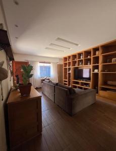 un grand salon avec un canapé et une télévision dans l'établissement Espaço inteiro com 3 quartos não compartilhado com outros no centro, à Miguel Pereira