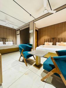 a bedroom with a bed and a table and chairs at JS Residency Luxe Collection Hotel Near Nizamuddin Railway Station in New Delhi