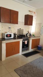 a kitchen with a stove and a microwave at Rose homes in Mombasa