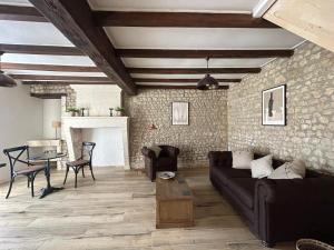 a living room with a couch and a table at Le Hibou -1 bed Gite in Porcheresse