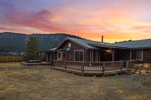 a log cabin with a deck and a sunset at Stapp Mountain Retreat in South Fork, CO in South Fork