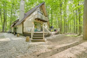 ein Haus mit einer Treppe im Wald in der Unterkunft Woodsy A-Frame Cabin with Lakes of the North Access in Mancelona