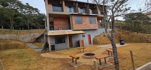 un bâtiment avec un foyer devant lui dans l'établissement Villa da Serra Studio com ar condicionado Quente/frio, à Conceição da Ibitipoca