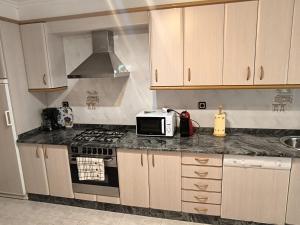 a kitchen with a stove and a microwave at Casa o Pontillón in Rabiño