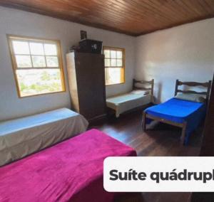 a bedroom with two beds and a chair and a couch at República Acrópole in Ouro Preto