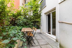 3 pièces proche de Paris avec terrasse et parking في شاتيلون: طاولة صغيرة و كرسيين في حديقة