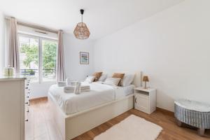 3 pièces proche de Paris avec terrasse et parking في شاتيلون: غرفة نوم بيضاء مع سرير ونافذة