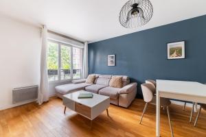 3 pièces proche de Paris avec terrasse et parking في شاتيلون: غرفة معيشة بها أريكة وطاولة