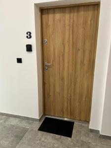 ソスノヴィエツにあるApartament 37のタイルフロアの客室内の木製ドア