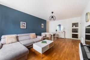 3 pièces proche de Paris avec terrasse et parking في شاتيلون: غرفة معيشة بها أريكة وطاولة