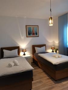 zwei Betten in einem Zimmer mit zwei Lampen und zwei Bettblenden in der Unterkunft MaMio in Šibenik