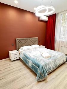 a bedroom with a bed and a red wall at 2 room in the very center of the city near the mega park and walking distance to the Arbat in Almaty