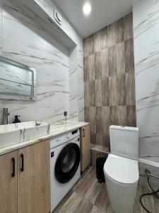 a bathroom with a washing machine and a sink at 2 room in the very center of the city near the mega park and walking distance to the Arbat in Almaty