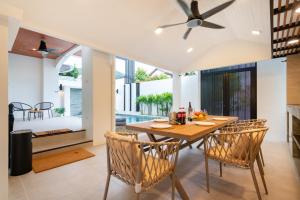 a dining room with a wooden table and chairs at At Bangla Patong Pool Moon villa in Patong Beach