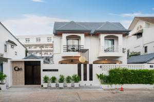 a white house with plants in front of it at At Bangla Patong Pool Moon villa in Patong Beach