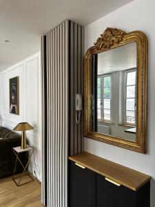 a living room with a mirror and a couch at Le Paon D'Or - En plein coeur du Vieux Troyes in Troyes