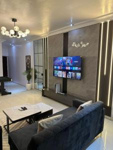 a living room with a couch and a flat screen tv at 2 Bedroom in Lekki Phase 1 in Lekki