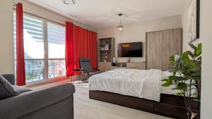 a bedroom with a bed and a couch and a tv at Ursus Pleasant Apartment by BookingHost in Warsaw