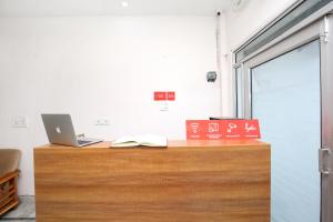 an office with a desk with a laptop and a book at Hotel O The Nest in Sohāna
