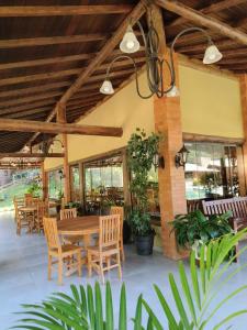 un patio esterno con tavolo e sedie in legno di Pousada Corrego da Luz a Casimiro de Abreu