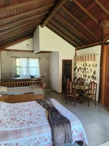 una camera da letto con due letti, un tavolo e delle sedie di Pousada Corrego da Luz a Casimiro de Abreu