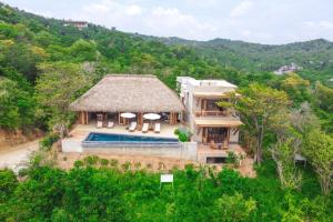 an aerial view of a house with a thatched roof at Casa Miguana - Chiwiro in San Agustinillo