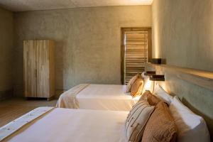 a bedroom with two beds and a window at Casa Miguana - Chiwiro in San Agustinillo