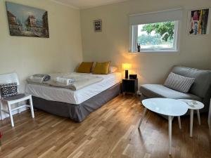 a bedroom with a bed and a couch and a table at Small Seaside Cottage in Saltsjöbaden
