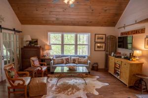 a living room with a couch and a table at Sweetwater Cottage - Private Cottage Tucked in the Woods - WJ & Boone - River Access in West Jefferson
