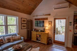 a living room with a couch and a table at Sweetwater Cottage - Private Cottage Tucked in the Woods - WJ & Boone - River Access in West Jefferson