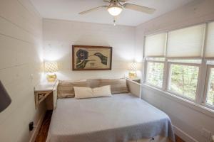 a bed in a room with two windows at Sweetwater Cottage - Private Cottage Tucked in the Woods - WJ & Boone - River Access in West Jefferson