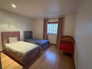 a bedroom with two beds and a window at House in Alcobaça in Alcobaça