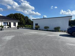 a white building with a car parked in a driveway at A7 Apartment 3 in Dätgen