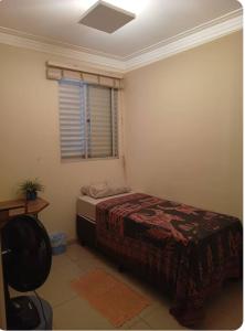 ein Schlafzimmer mit einem Bett und einem Fenster in der Unterkunft Quarto apê completo , Centro, Damhas e Rodoviária , localização privilegiada in Sao Jose do Rio Preto