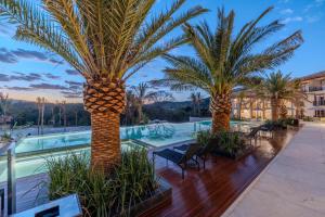 a resort with palm trees and a swimming pool at PYRENÉUS RESIDENCE GAV Resorts in Pirenópolis +52 photos