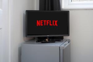 リンカーンにあるStudio in Lincolnの冷蔵庫の上に「Netflix」と書かれたテレビが置かれている