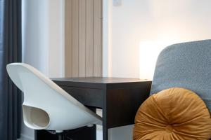 リンカーンにあるStudio in Lincolnのデスクとテーブルの横に白い椅子