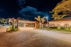 a building with a palm tree next to a street at PYRENÉUS RESIDENCE GAV Resorts in Pirenópolis