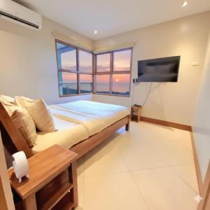 a bedroom with a bed and a flat screen tv at BREATHTAKING BAYVIEWS - 1-5 BR Luxury and Superior Condos with Panoramic Bay Views, Balcony, Gym, Pool & Netflix - Housekeeping Available - in Manila