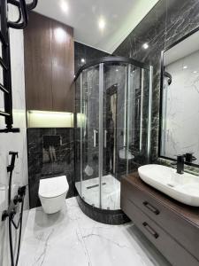 a bathroom with a shower and a toilet and a sink at Tashkent Seoul Moon Apartments in Yakkasaray