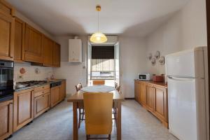 a kitchen with a table and a white refrigerator at Monterosso-Cozy Apartment in CastellʼArquato