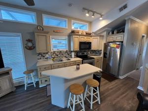 a kitchen with a white island and a refrigerator at Sandy's River House in Bainbridge