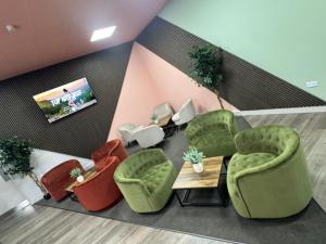 a lobby with green chairs and a table and a tv at 248 Halls in Middlesbrough