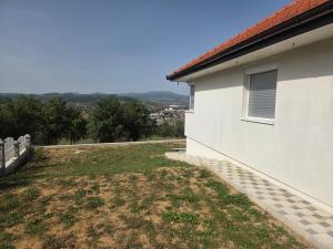 una casa blanca con un patio al lado de un edificio en Kuća snova, en Ilijaš 5 fotos más