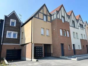 a large brick building with a large garage at Maison neuve proche plage et commerces in Stella-Plage