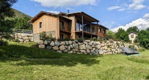 a house with a stone wall in front of it at Balcons de Sorgeat - Chambres d'hôtes - Ecolodge en montagne in Sorgeat