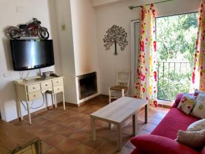 een woonkamer met een bank en een tv bij LA CASA del CASTAÑO in Aracena